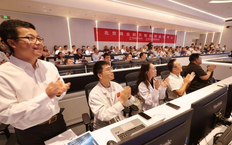 飞行试验任务取得圆满成功，工作人员鼓掌庆祝。新京报记者 李木易 摄